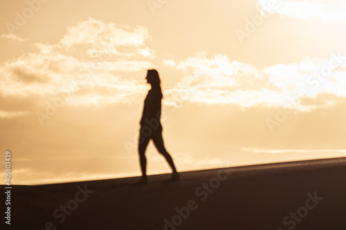 Woman shadow in the dunes during a sunset in Gran Canaria