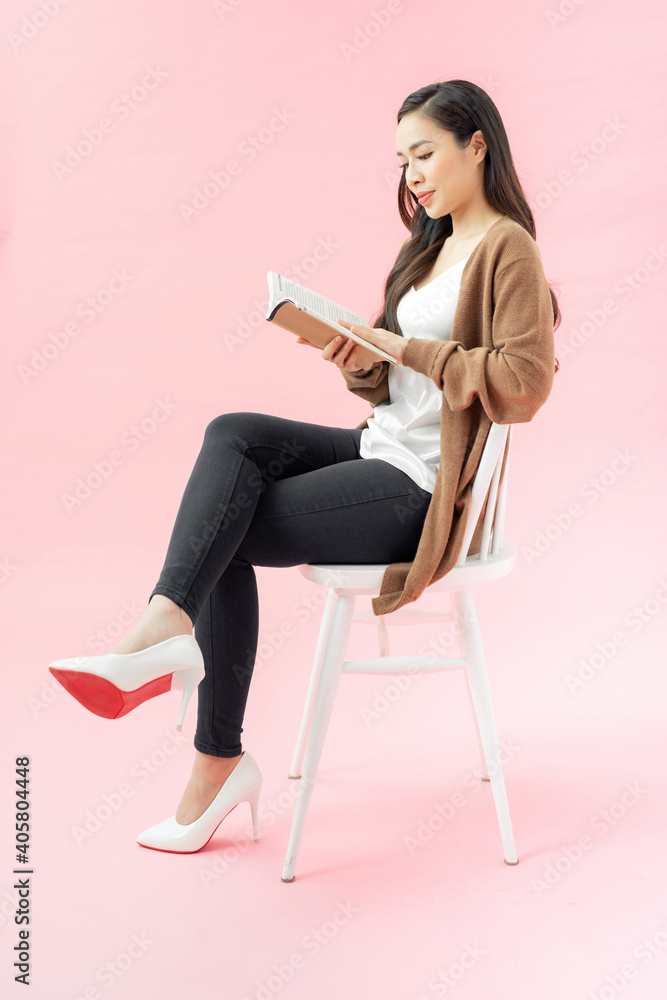 reading young woman with brown book sitting on chair reading young woman with brown book sitting on chair