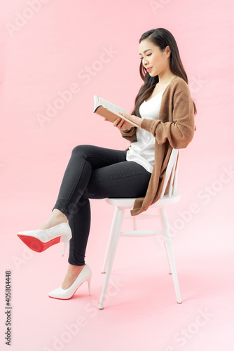 reading young woman with brown book sitting on chair