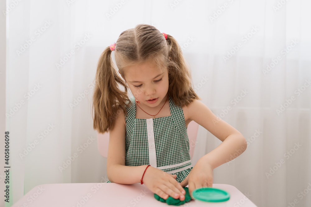 Little girl with a lovely face play with clay molding shapes, learning through playing with colored plasticine developing creativity Little girl with a lovely face play with clay molding shapes, learning through playing with colored plasticine developing creativity