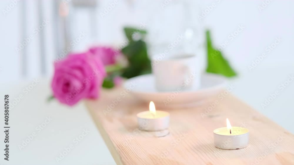 Beautiful spa setting with pink candle and flowers on wooden background. Concept of spa treatment in salon. Atmosphere of relax, serenity and pleasure. Luxury lifestyle. Beautiful spa setting with pink candle and flowers on wooden background. Concept of spa treatment in salon. Atmosphere of relax, serenity and pleasure. Luxury lifestyle.