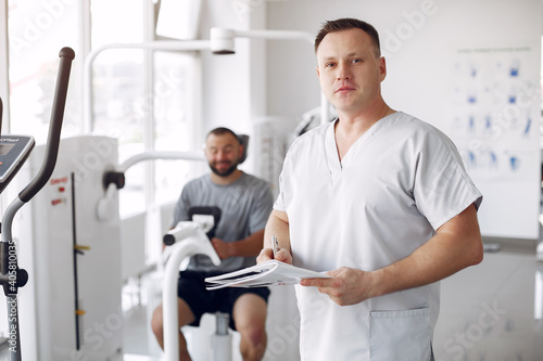 Patient has a rehabilitation in physiotherapy clinic. Doctor in a uniform. photo