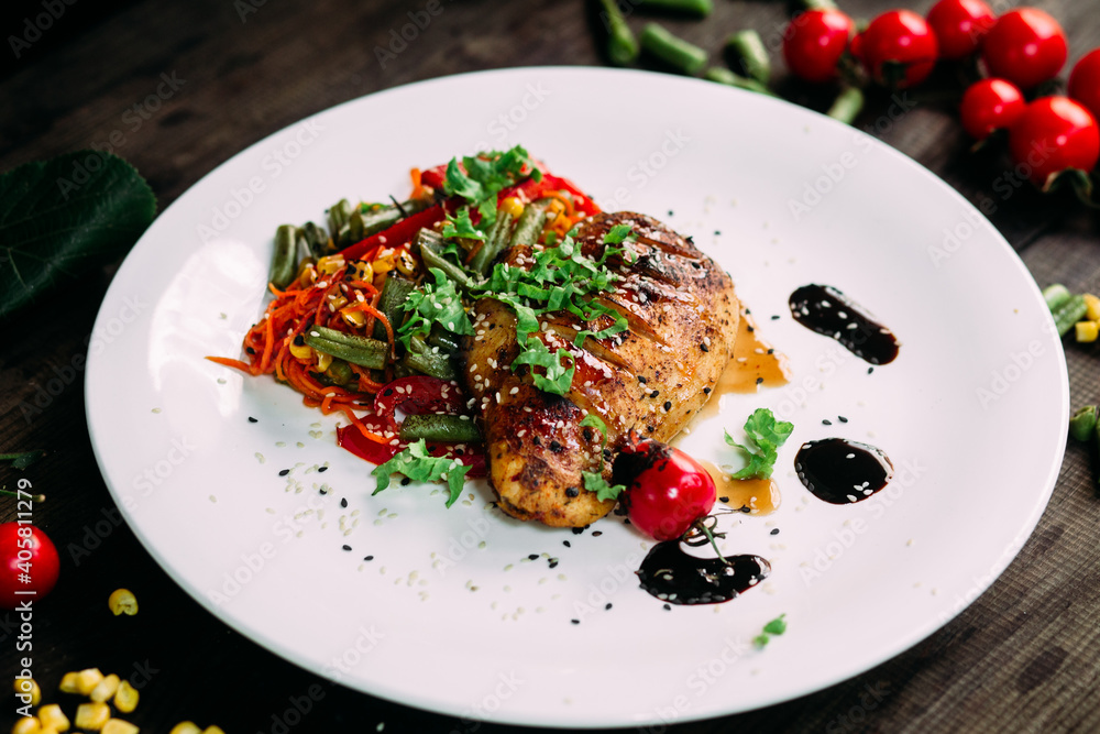 Chicken fillet baked with vegetables on a white plate Chicken fillet baked with vegetables on a white plate