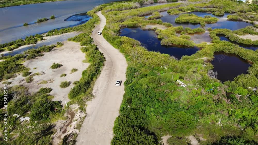 Aerial view of a single car park off-road surrounded by wetlands and beautiful trees. Aerial view of a single car park off-road surrounded by wetlands and beautiful trees.