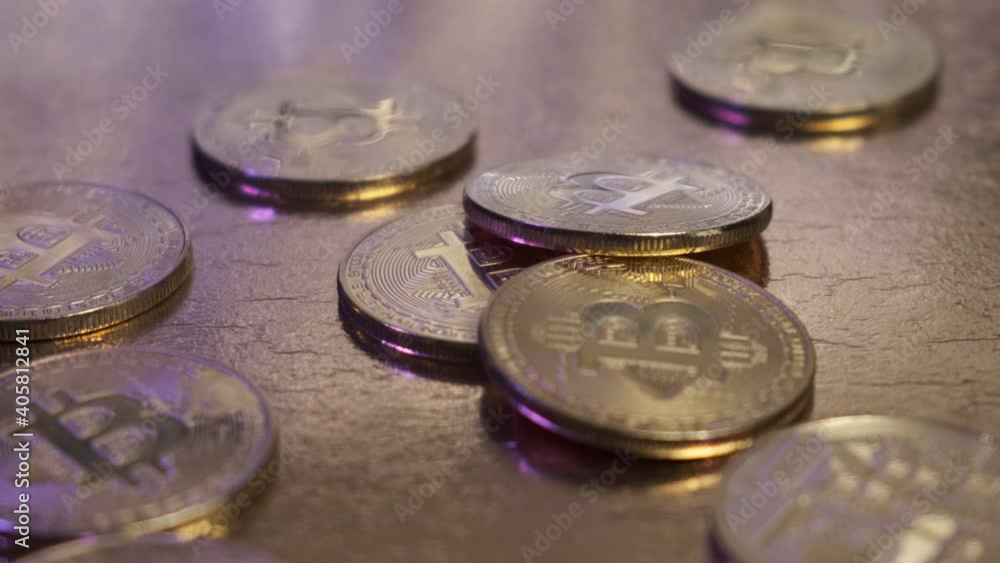 Bitcoin coins are close-up rotating on a gold table. Bitcoin coins are close-up rotating on a gold table.