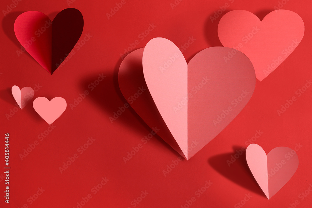 Valentines day concept,Paper cutting technique ,Paper hearts on red background.