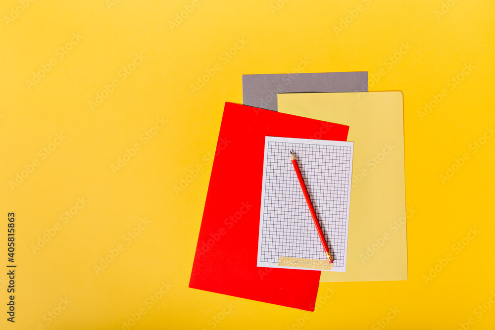 Set of multi-colored paper and red pencil on orange background Set of multi-colored paper and red pencil on orange background