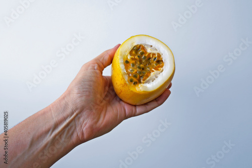 Half passion fruit on hand on a bright background 