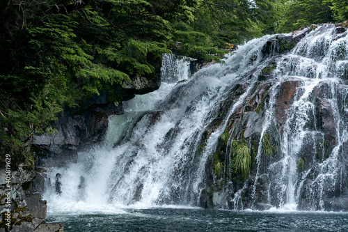 waterfall hidden among forests nestled between high and remote mountains