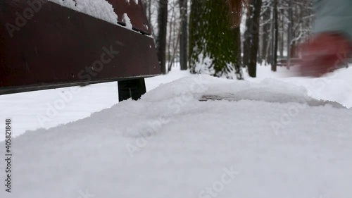 Wallpaper Mural The person's hand clears the snow from the bench in winter on the street. Torontodigital.ca