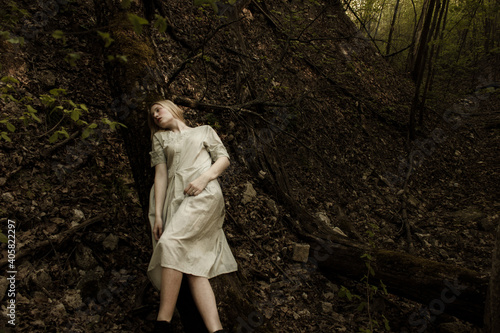 Portrait of a beautiful mysterious woman with blond hair in the forest.  like a fairytale. Warm tone