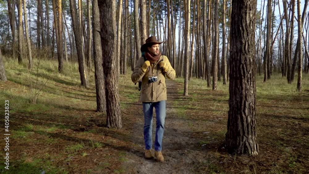 Backpacker with a camera walks along a trail in the forest. Travel concept. 4K Backpacker with a camera walks along a trail in the forest. Travel concept. 4K