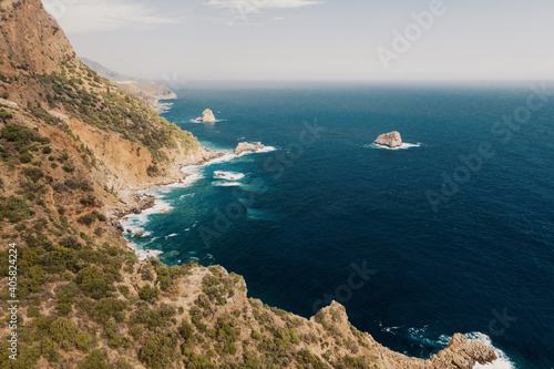 View of an empty rocky coastline  azure sea  mountain and rocks  Turkey