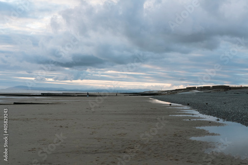 relaxing and gentle calming waves flowing into a beach on an gloomy overcast day photo