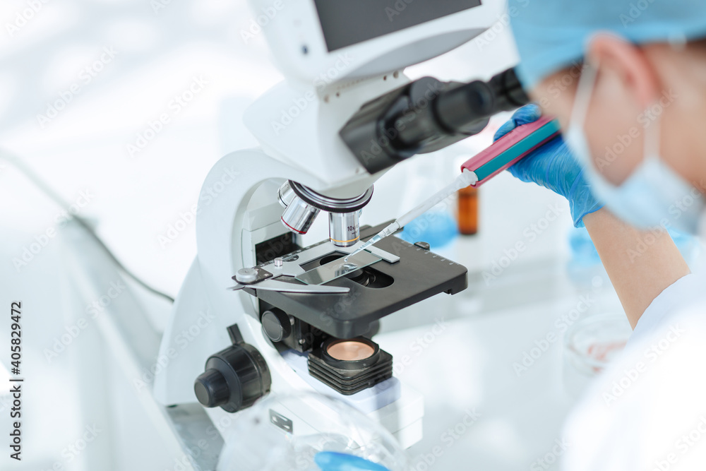 close up. researcher testing the blood under a microscope. close up. researcher testing the blood under a microscope.