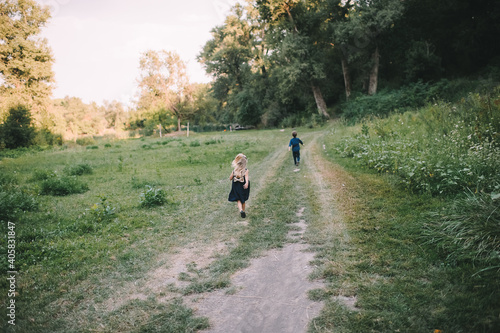 boy and girl running along the path in the forest