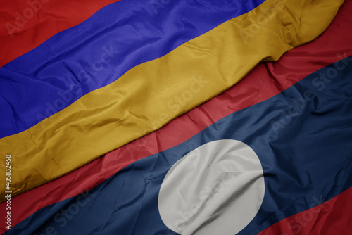 waving colorful flag of laos and national flag of armenia.