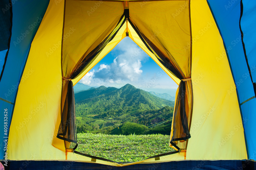 open tent with greenery mountains landscape view against blue sky and large clouds