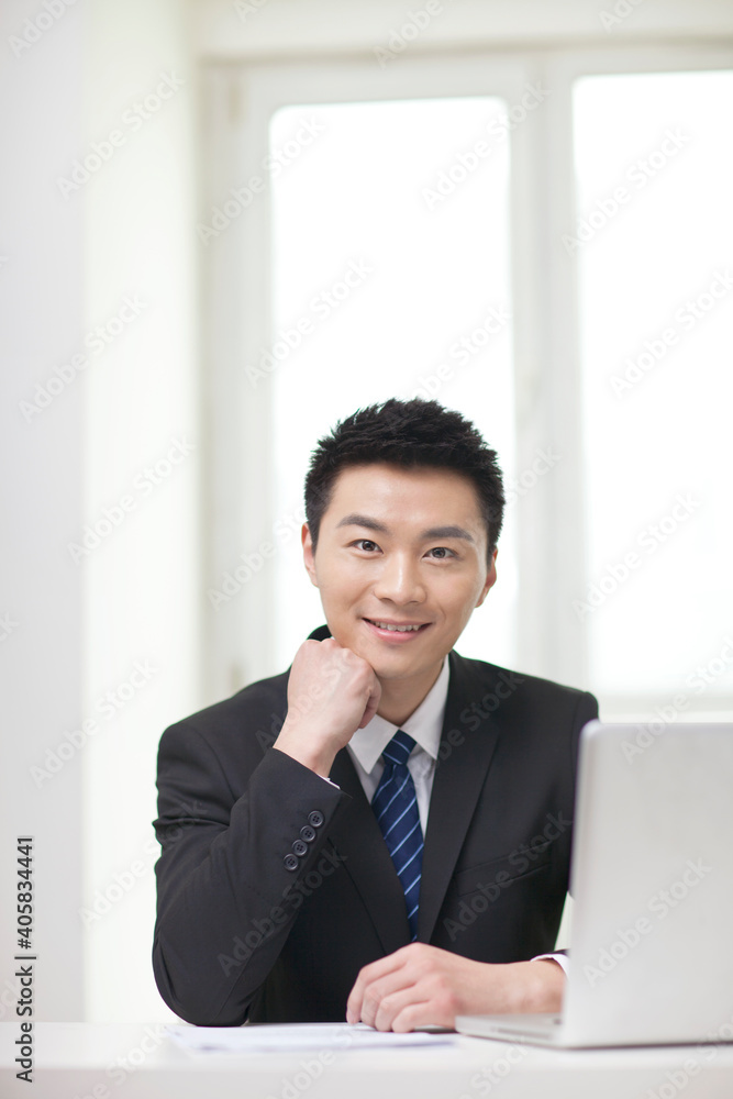 Portrait of business man sitting by laptop Portrait of business man sitting by laptop