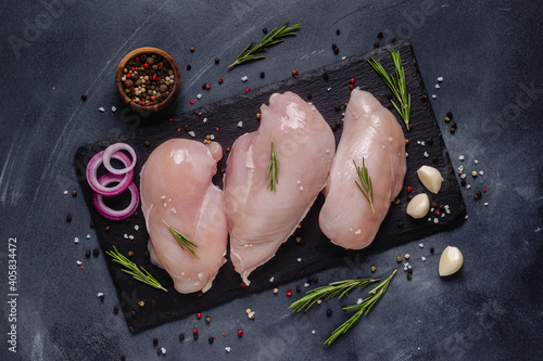 Fotografia Raw chicken fillet with spices and herbs.