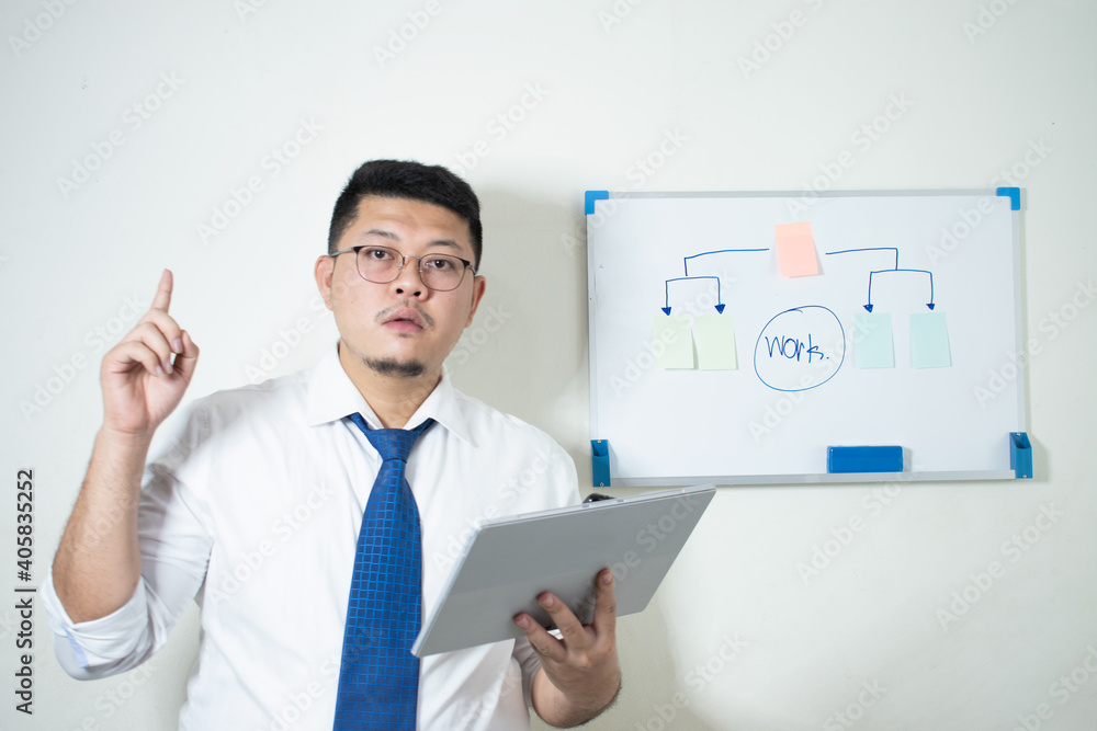 Young Asian businessman Wear a white shirt Tie a blue tie using his tablet Young Asian businessman Wear a white shirt Tie a blue tie using his tablet