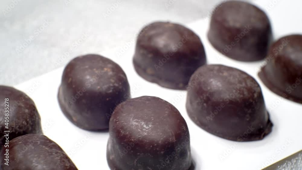 Food background.Chocolates candy move slowly along the conveyor.Close-up. Food background.Chocolates candy move slowly along the conveyor.Close-up.