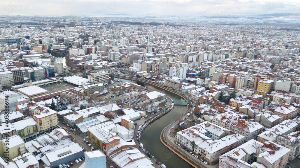 Aerial view of snowy buildings and city roads at the winter. 