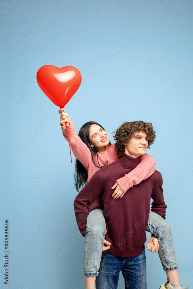 Heart balloon, embracing. Beautiful couple in love on blue studio background. Saint Valentine's Day, love, relationship and human emotions concept. Copyspace. Young man and woman look happy together. Heart balloon, embracing. Beautiful couple in love on blue studio background. Saint Valentine's Day, love, relationship and human emotions concept. Copyspace. Young man and woman look happy together.