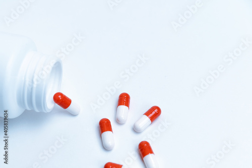 capsules with medicine and an empty bottle on a white background.