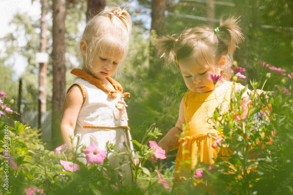 Two little girls sisters watering flowers Two little girls sisters watering flowers