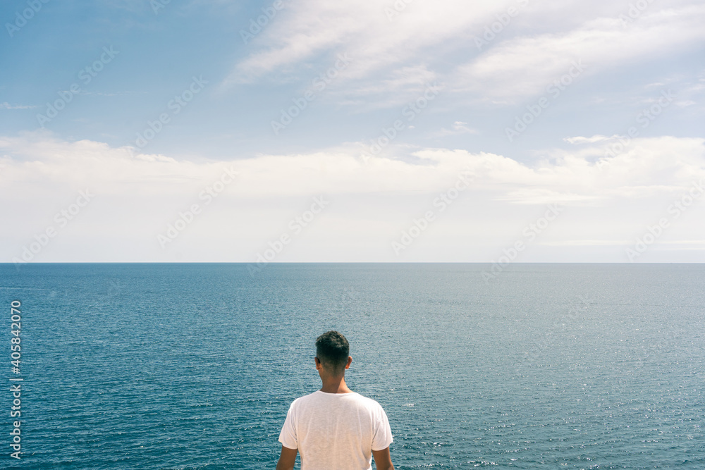 Concept of discovery, freedom and adventure - portrait of a man looking at the sea
