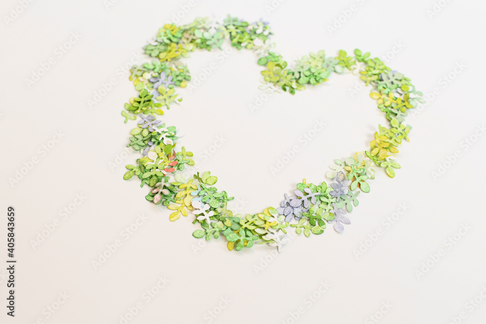 Green leaves of paper, folded in one big heart on a white background, as festive feelings on Valentine's Day, love.
View from above. Copyspace.