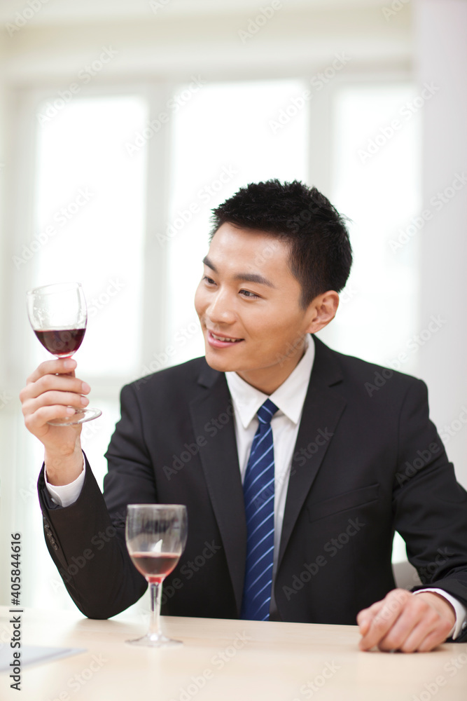 Portrait of businessman at desk with a glass of wine Portrait of businessman at desk with a glass of wine