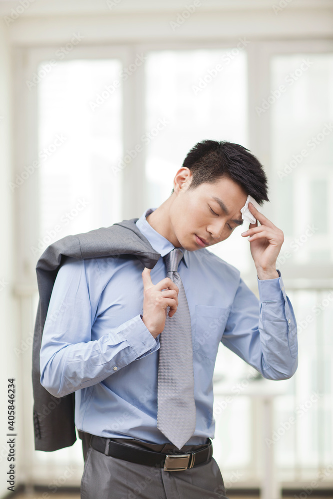 Portrait of young business man wiping forehead Portrait of young business man wiping forehead