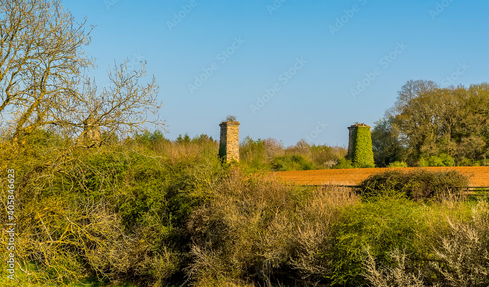 A view across the tree line towards the remains of the railway viaduct on the outskirts of  Hook Norton, Oxfordshire, UK