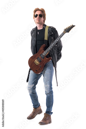 Cool attitude young handsome rock music guitarist with hands on back and electric guitar. Full body isolated on white background. 