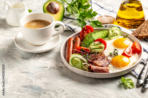 Fried egg with sausages, bacon, egg, avocado, beans, tomatoes and toasts on a plate. catering, banner, menu, recipe, place for text