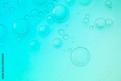 Creative neon background with drops. Glowing abstract backdrop with vibrant gradients on bubbles. Turquoise overflowing color