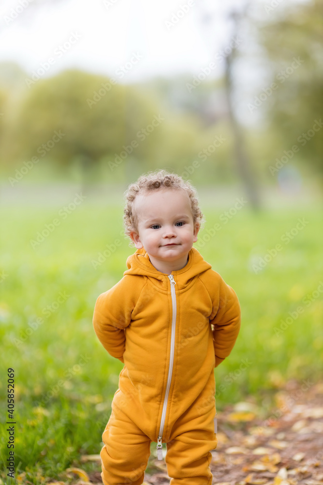 Portrait of little boy in yellow overalls in park Portrait of little boy in yellow overalls in park