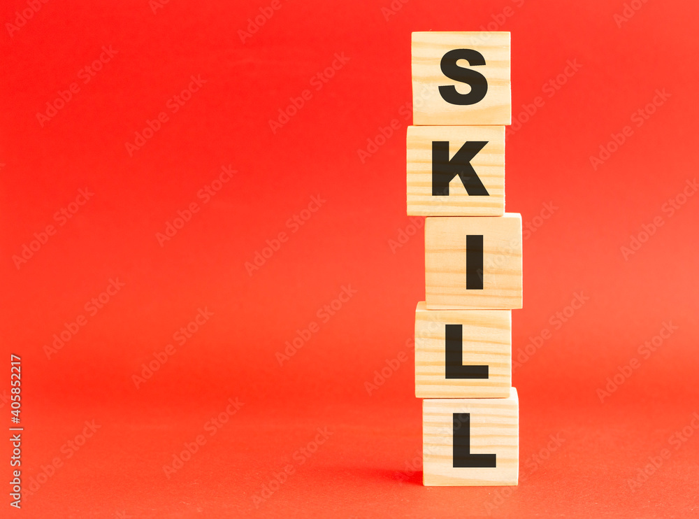 Wooden cubes with word SKILL. Wooden cubes on a red background. Free space on the left. Wooden cubes with word SKILL. Wooden cubes on a red background. Free space on the left.