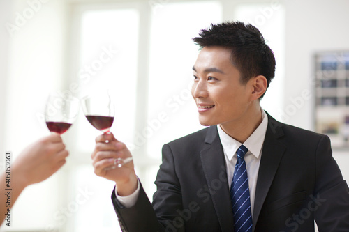 Portrait of businessman holding a glass of wine and toasting