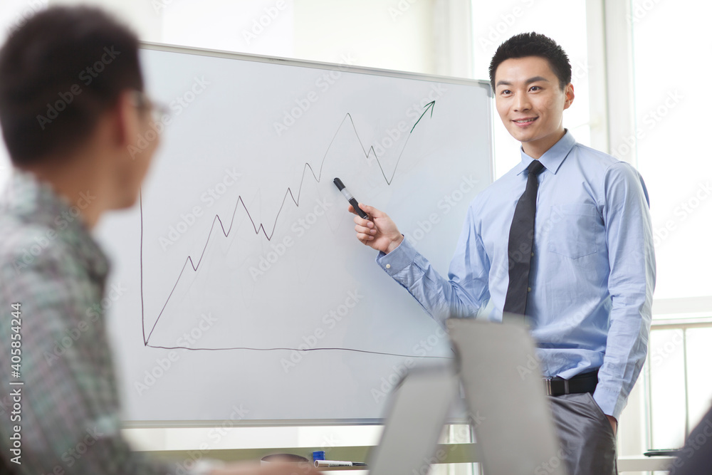 Portrait of young businessman standing in front of the whiteboard Portrait of young businessman standing in front of the whiteboard