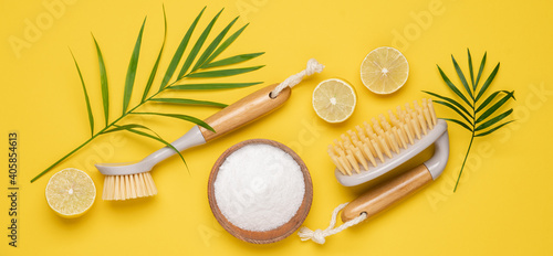 Eco brushes, sponges, lemon and soda on yellow background. Eco natural cleaning products. Cleaner concept
