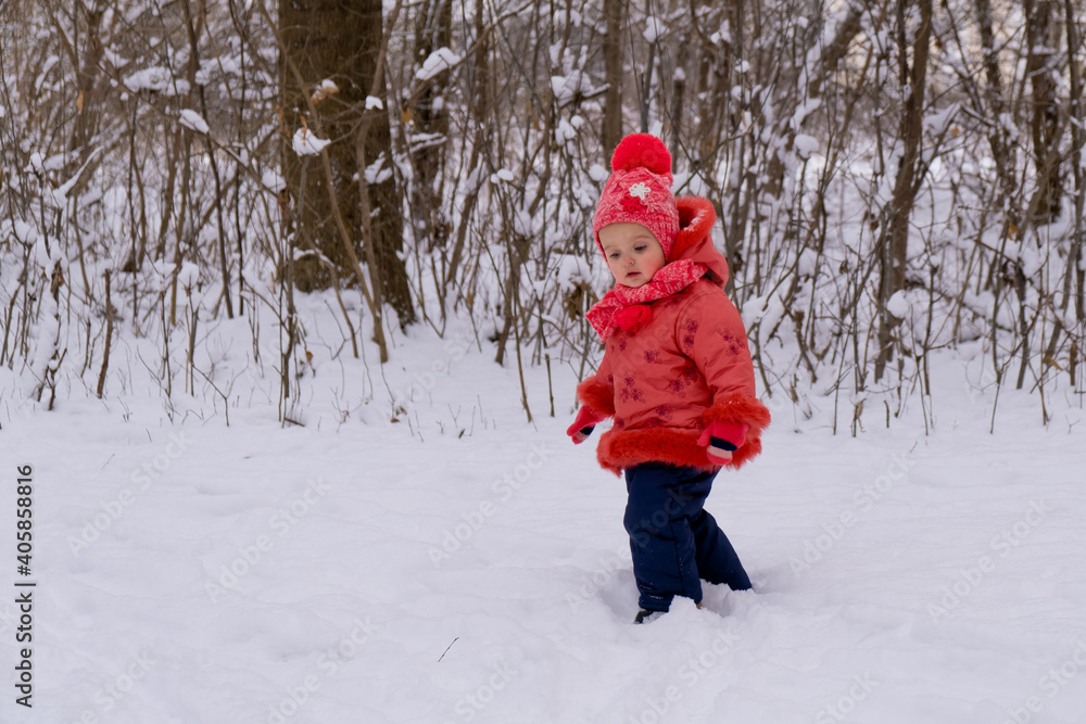 Baby girl walking on snow. Winter time.