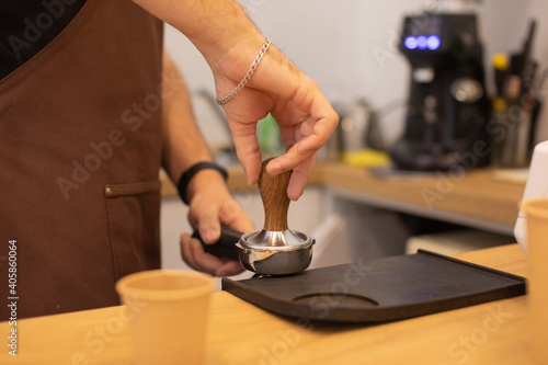 Barista making coffee in coffeeshop.