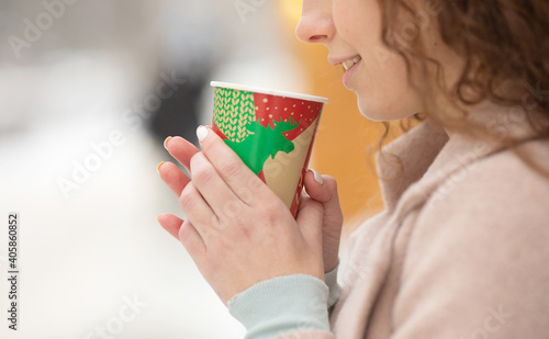 Portrait of woman drinking coffee in winter outdoor.