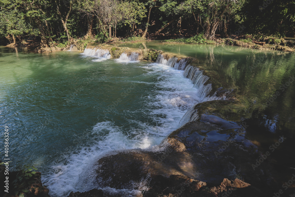 Obraz premium Deep forest waterfall stream view. Forest waterfall creek. Waterfall in deep forest. Waterfall river forest scene