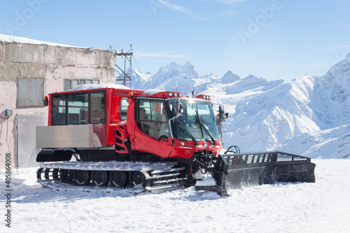 Tractor removing snow in the snow-white tall mighty mountains Elbrus, ski resort, the Republic of Kabardino-Balkaria, Russia