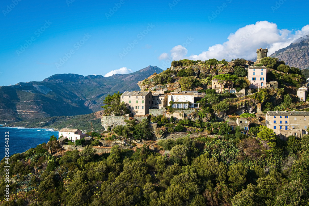 The village Nonza, located both the side of a cliff, Cap Corse, Corsica, France. Tower (Tour Paoline) on top of the cliff