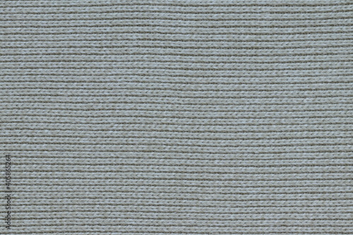 The texture of a light knitted sweater fabric. 